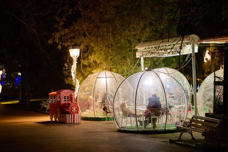 Cozy outdoor dining in festive igloos at night. December 13, 2025 Sinaia Romania.のeditorial素材