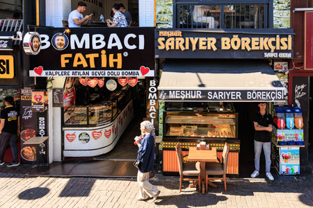 Street scene with bakery and food stall featuring outdoor seating and people in urban setting. August 12, 2025 Istanbul Turkey.のeditorial素材