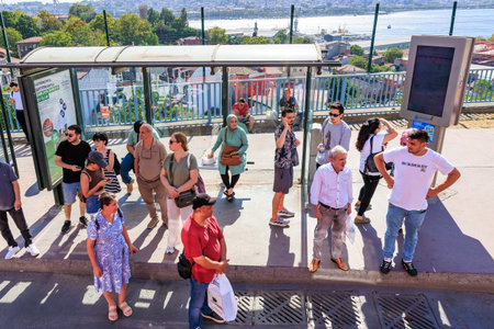 Diverse group of people waiting at a bus stop overlooking a river. August 12, 2025 Istanbul Turkey.