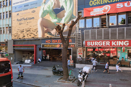 Urban street scene with restaurants and advertisements in a city setting. August 12, 2025 Istanbul Turkey.のeditorial素材