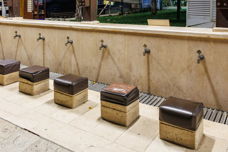 Traditional stone ablution fountain with taps and seats in a public park. August 9, 2025, 2 Bursa Turkey.のeditorial素材