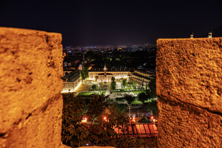 Night view of illuminated historic courtyard in urban landscape through stone walls. August 9, 2025, 2 Bursa Turkey.のeditorial素材