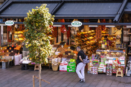 Caucasian young male shopping at vibrant outdoor spice and nut market. August 12, 2025 Istanbul Turkey.のeditorial素材