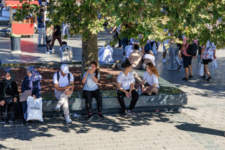 Young adults and families relaxing in a vibrant urban park setting. August 12, 2025 Istanbul Turkey.のeditorial素材