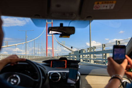 Driving across a modern suspension bridge on a sunny day. August 2, 2025, Canakkale Turkey.のeditorial素材