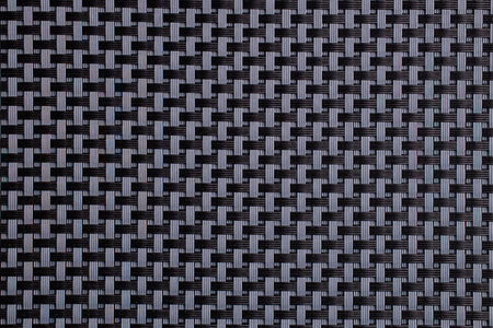 Close-up of black and gray woven carbon fiber textile pattern.
