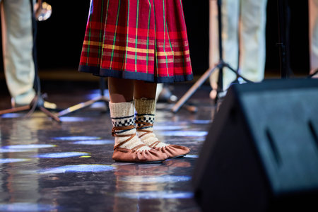 Traditional dance performance with plaid skirt and wool socks on stage.の写真素材