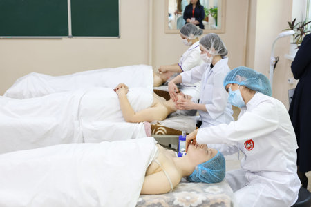 Spa treatment with caucasian females receiving facials from young adult professionals. April 30, 2024 Balti Moldova.のeditorial素材