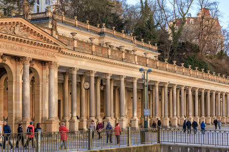 Historic colonnade with visitors in european spa town. March 18, 2025, Karlovy Vary, Czech Republic.のeditorial素材