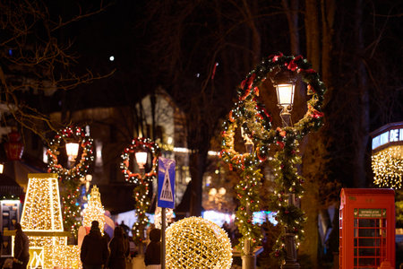 Festive night market with illuminated christmas decorations and lanterns. December 13, 2025 Sinaia Romania.のeditorial素材