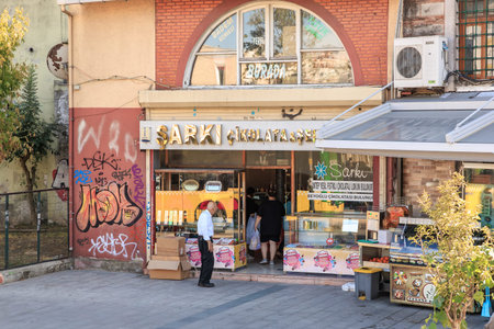 Street view of turkish chocolate shop with people entering and graffiti on walls. August 12, 2025 Istanbul Turkey.のeditorial素材