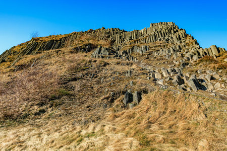 Scenic basalt column formation under clear blue sky.