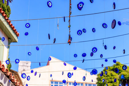 Eye ornaments hanging outdoors against blue sky for protection.の写真素材