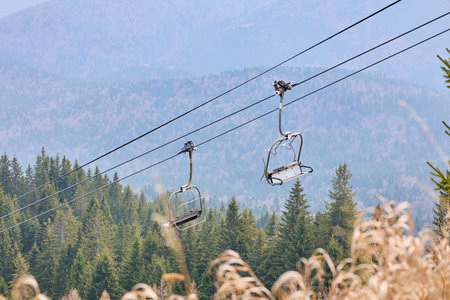 Empty ski lift over mountain forest in autumn.の写真素材