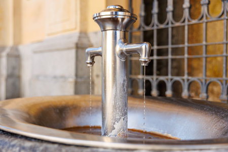 Close-up of stainless steel outdoor water fountain with gentle flowing streams.の写真素材