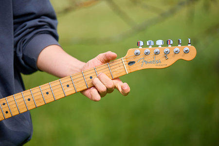 Caucasian male adult playing electric guitar outdoors close-up. June 21, 2025 Edinet Moldova.