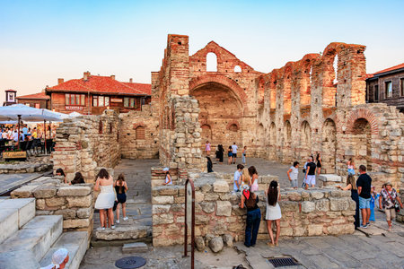 Ancient ruins in nessebar with tourists exploring historical architecture. August 1, 2025, Nessebar...