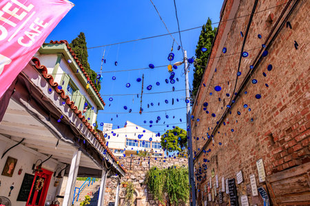 Charming street with blue evil eye charms and rustic architecture in turkey. August 3, 2025,...