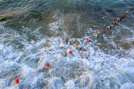 Top view of coastal waves and ocean buoys in turbulent sea waters.