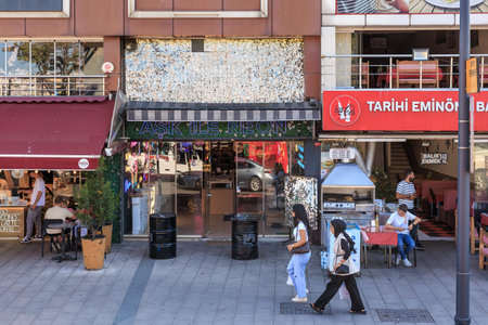 Busy urban street with restaurant and pedestrians in daylight. August 12, 2025 Istanbul Turkey.