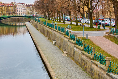 Riverside walkway with trees and bridge in european cityscape. March 15, 2026, Hradec Kralove, Czech Republic.のeditorial素材
