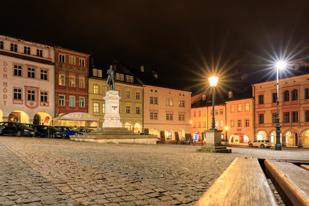 Historic european town square at night with illuminated statue and colorful buildings. March 15,...