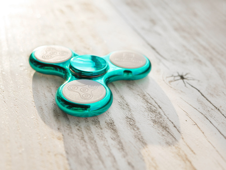 Popular fidget spinner toy on white wood backgroundの写真素材