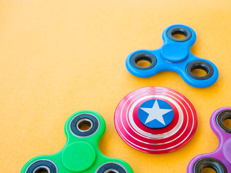 Popular colourful fidget spinner toy on a colored backgroundの写真素材