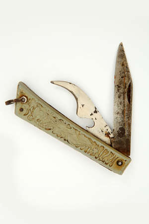 Old vintage rusty pocket knife with the tool for opening of canned food