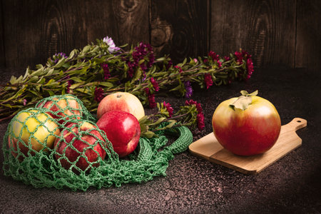 Ripe apples in a string bag on a wooden background. fresh harvest of applesの写真素材
