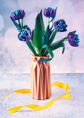 Bouquet of blue tulips in vase on light backgroundの写真素材
