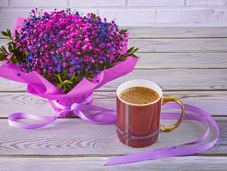 A bouquet of hyposophila flowers, a viva magenta cup. Festive still life in purple colors on a wooden and brick background.の写真素材