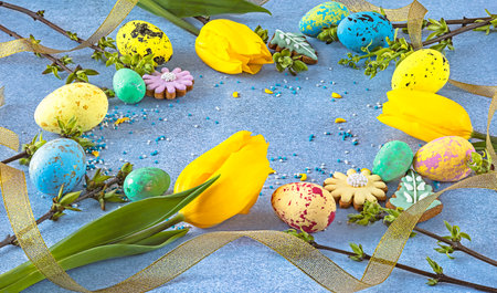Easter eggs and spring flowers on a blue background. top view.