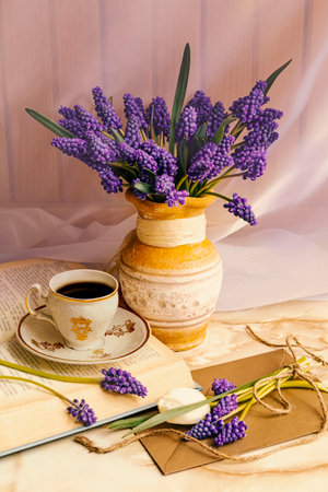 Cup of coffee, book and muscari flowers on a wooden backgroundの写真素材