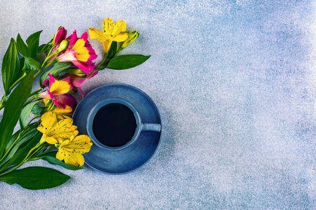 Cup of coffee and alstroemeria flowers on stone background. top view with copy spaceの写真素材