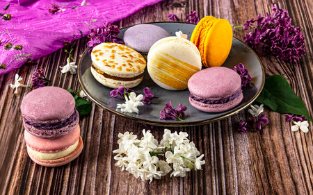 Colorful macaroons and lilac flowers on a wooden backgroundの写真素材