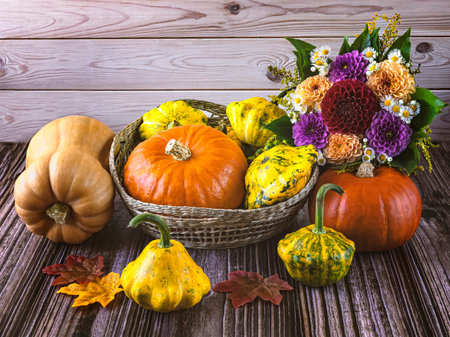 Autumn composition with pumpkins, flowers and leaves on wooden backgroundの写真素材