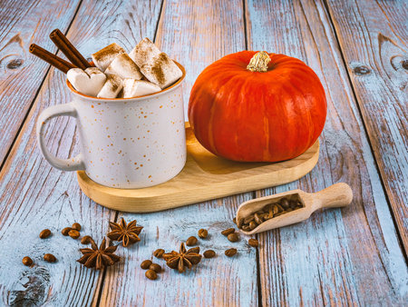 Cup of coffee with marshmallows and pumpkin on wooden backgroundの写真素材