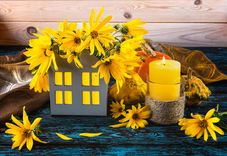 Autumn still life with yellow flowers and pumpkins on blue wooden backgroundの写真素材