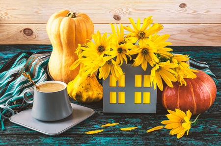 Autumn still life with pumpkins and a cup of coffee on a wooden backgroundの写真素材