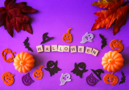 Halloween background with pumpkins, ghosts and autumn leaves on purple backgroundの写真素材