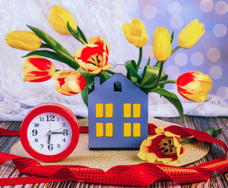 Bouquet of tulips and alarm clock on a wooden backgroundの写真素材