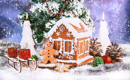 Christmas gingerbread house with Christmas tree in the background. Greeting card.の写真素材