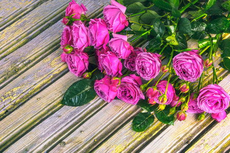 Bouquet of pink roses on a wooden background. View from above.の写真素材