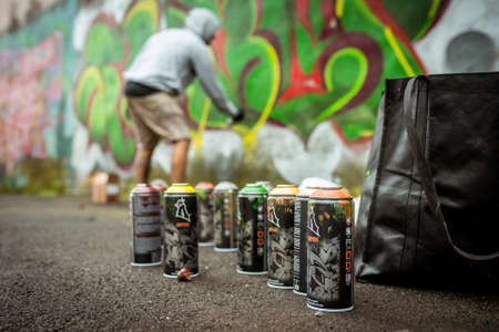 Spray paint cans stand istand against the background of a painting artist on "Street Art Week" festival on July 17, 2019 in Novokuznetsk, Kemerovo Region, Russian Federation.のeditorial素材