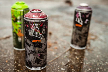 Used spray paint cans Arton stand in the rain on wet asphalt on "Street Art Week" festival on July 18, 2019 in Novokuznetsk, Kemerovo Region, Russian Federation.のeditorial素材