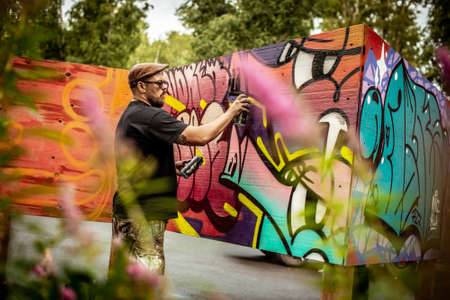 street artist spray paint on plywood on the wall on Street Art Week festival on July 20, 2019 in...