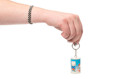 Woman hand holds key ring isolated on a white background.の写真素材