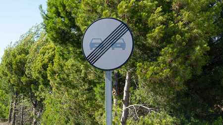End of No overtaking road traffic sign closeup on country road
