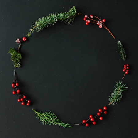 Christmas round frame made of natural winter things on dark blackboard. Flat lay. Christmas concept.の写真素材